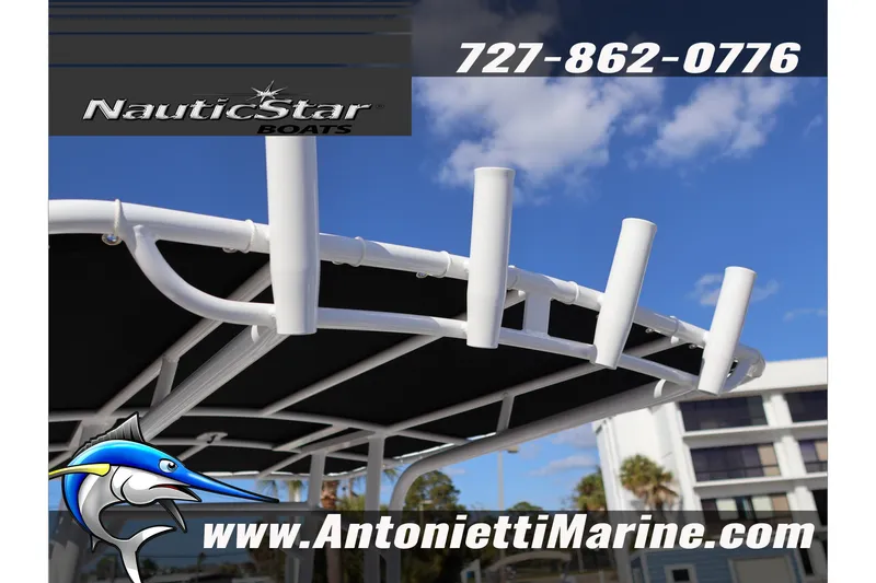 Slide: The Image of 2026 NauticStar 222 Offshore boat with rod holders and canopy, blue sky background. - 50