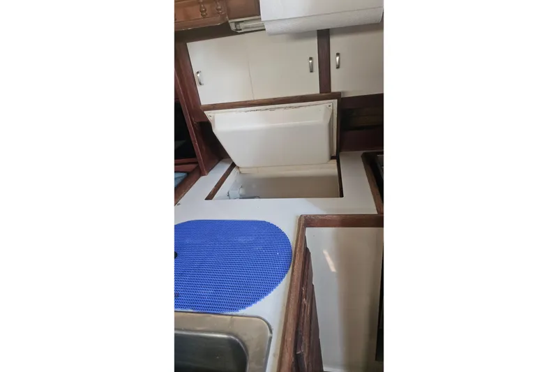 Slide: The Image of Interior of 1988 Catalina 34 sailboat galley with storage compartments and blue mat. - 14