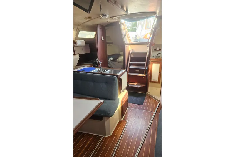 Slide: The Image of Interior of 1988 Catalina 34 sailboat with wood flooring and cozy seating area. - 22