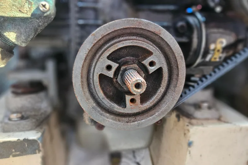Slide: The Image of Close-up of a Catalina 34 engine component, 1988 model, showing a rusty pulley and belt. - 29
