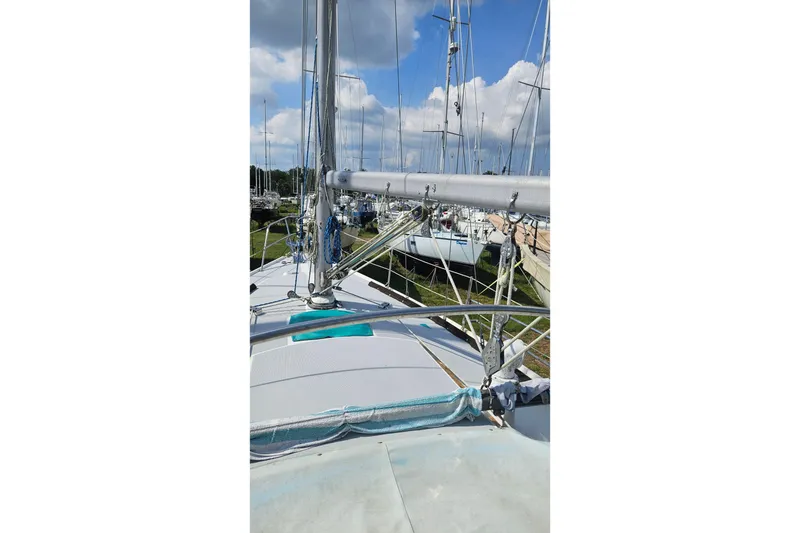 Slide: The Image of 1988 Catalina 34 sailboat deck view with masts and rigging under blue sky. - 5