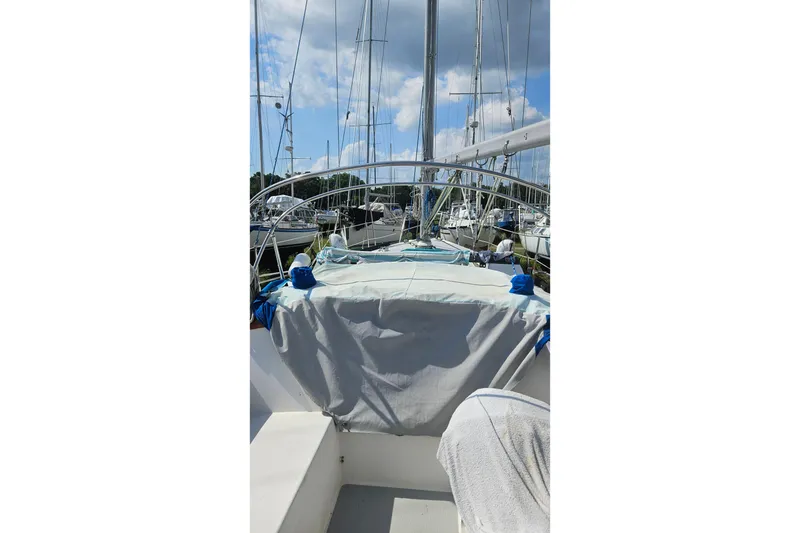 Slide: The Image of 1988 Catalina 34 sailboat docked at marina under cloudy sky. - 6