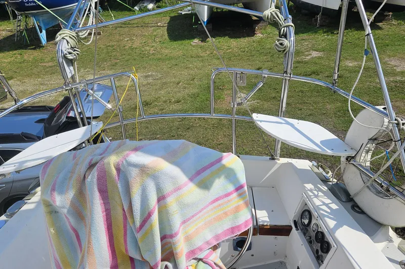 Slide: The Image of 1988 Catalina 34 sailboat cockpit with striped towel, parked on grass. - 8