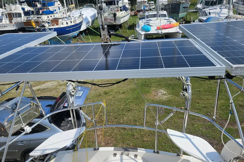 Slide: The Image of 1988 Catalina 34 sailboat with solar panels, docked among other boats. - 9