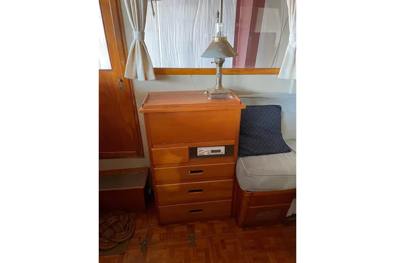 Slide: The Image of 1978 Grand Banks GB36570 interior with wooden drawers, lamp, and cushioned seating. - 13