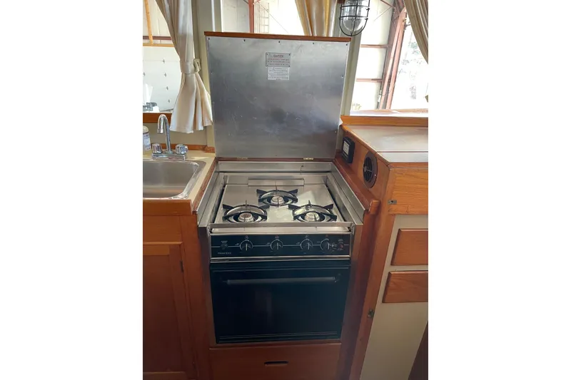 Slide: The Image of 1978 Grand Banks GB36570 boat kitchen with stove, oven, and sink. - 21
