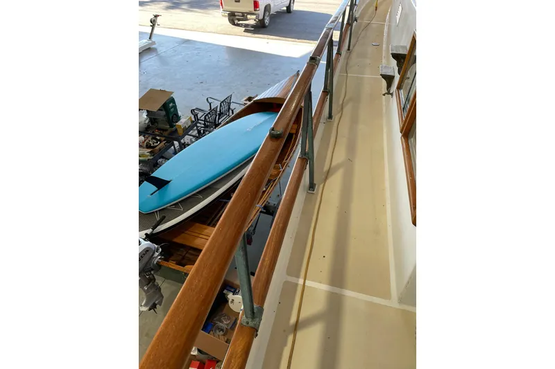 Slide: The Image of 1978 Grand Banks GB36570 yacht deck with wooden railings and a blue surfboard. - 23
