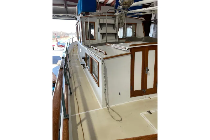Slide: The Image of 1978 Grand Banks GB36570 boat deck with wooden railings and cabin doors. - 4
