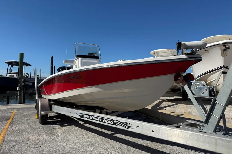 Slide: The Image of 2017 Blazer Bay 2220 Fisherman boat on trailer, red and white design, clear sky background. - 2