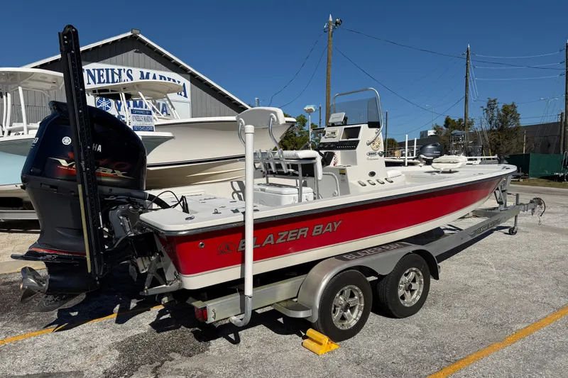 Slide: The Image of 2017 Blazer Bay 2220 Fisherman boat on trailer at marina, red and white design. - 5