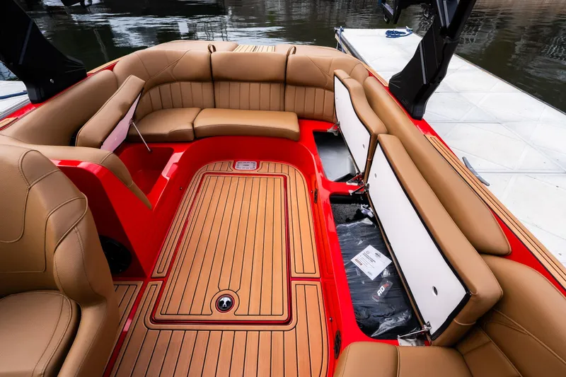 Slide: The Image of 2026 MB B52 23 Classic boat interior with tan seating and wood flooring at a dock. - 27