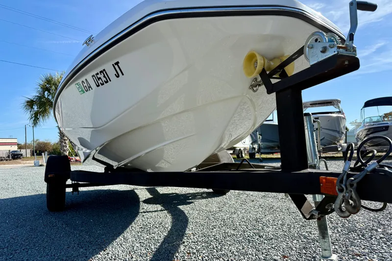 Slide: The Image of 2017 Scarab 165 G boat on trailer, parked on gravel lot under clear blue sky. - 8