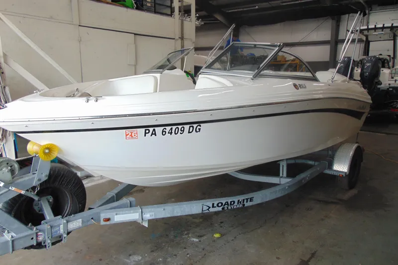 The Image of White 2011 Mariah R18.9 boat on trailer in garage setting. - 1