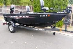 The Image of 2025 Tracker Super Guide V-16 T fishing boat on trailer, parked on street. - 1