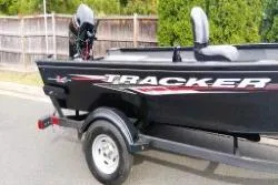 Slide: The Image of 2025 Tracker Super Guide V-16 T boat on trailer, parked outdoors. - 7