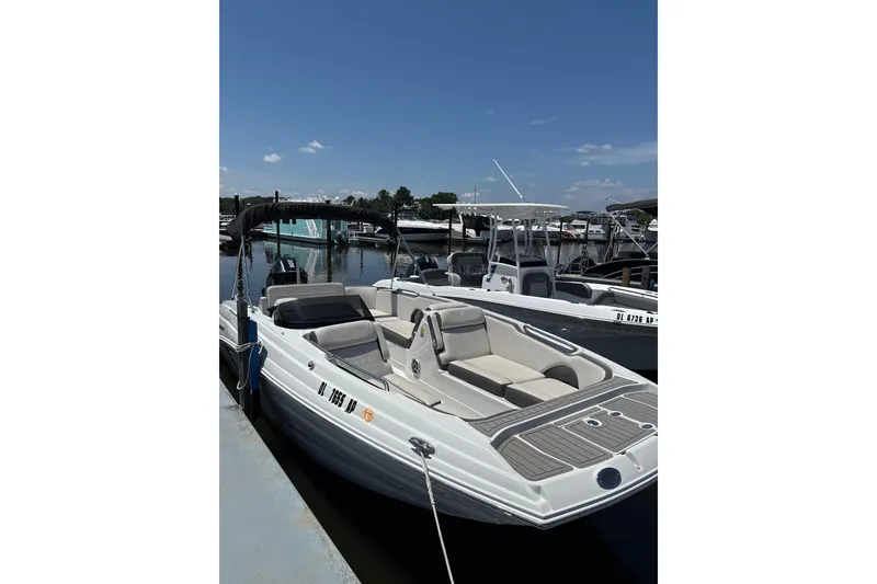 The Image of 2024 Crownline Eclipse E230 XS boat docked at marina under clear blue sky. - 1