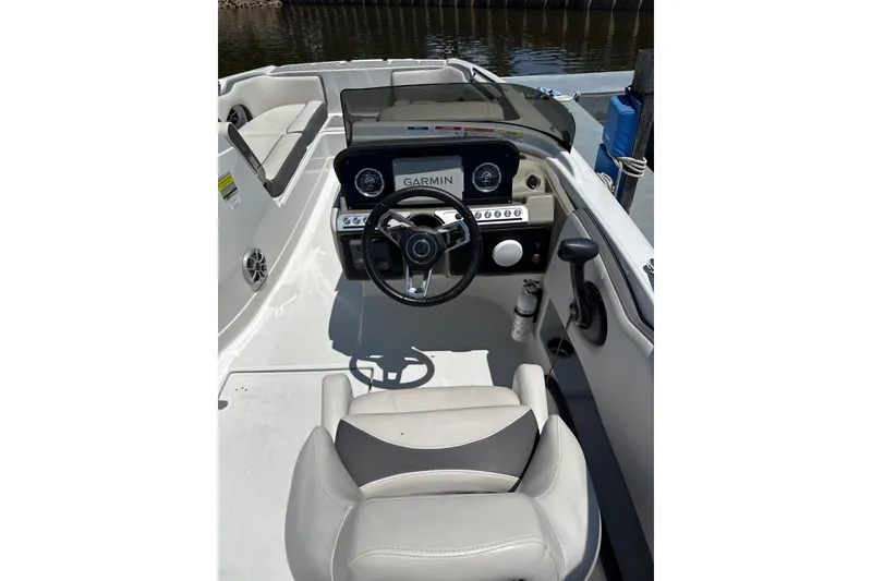 Slide: The Image of 2024 Crownline Eclipse E230 XS boat cockpit with steering wheel and Garmin display. - 3
