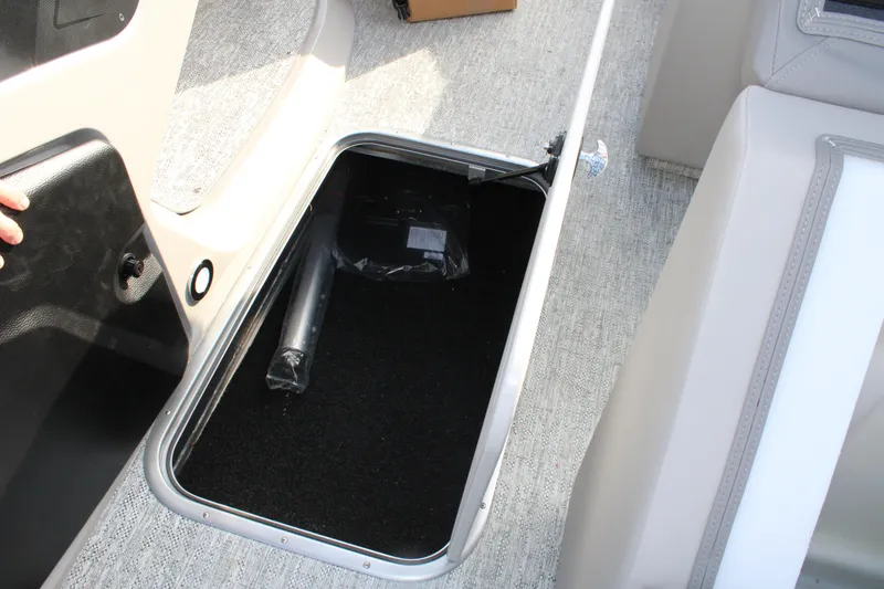 Slide: The Image of Storage compartment in 2026 Premier 210 Sunsation RE XSD boat, featuring carpeted interior. - 13