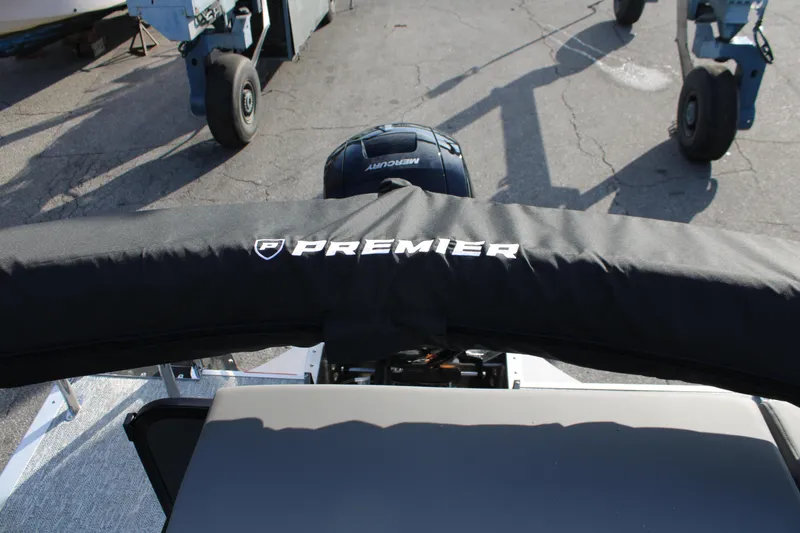 Slide: The Image of 2026 Premier 210 Sunsation RE XSD boat with covered engine, parked on pavement. - 14