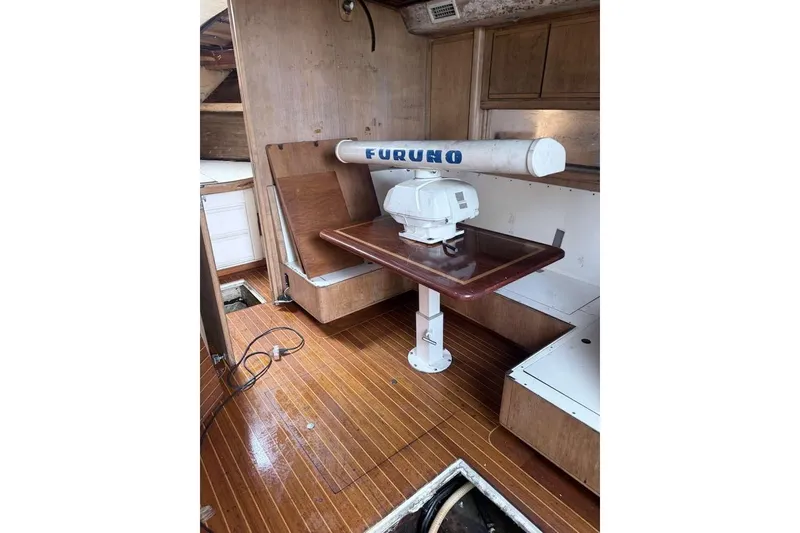 Slide: The Image of 1995 Bertram 46 Moppie interior with Furuno radar, wooden flooring, and seating area. - 13