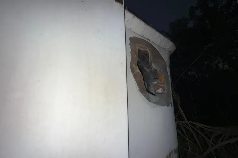 Slide: The Image of Damaged hull of 1995 Bertram 46 Moppie boat at night. - 15