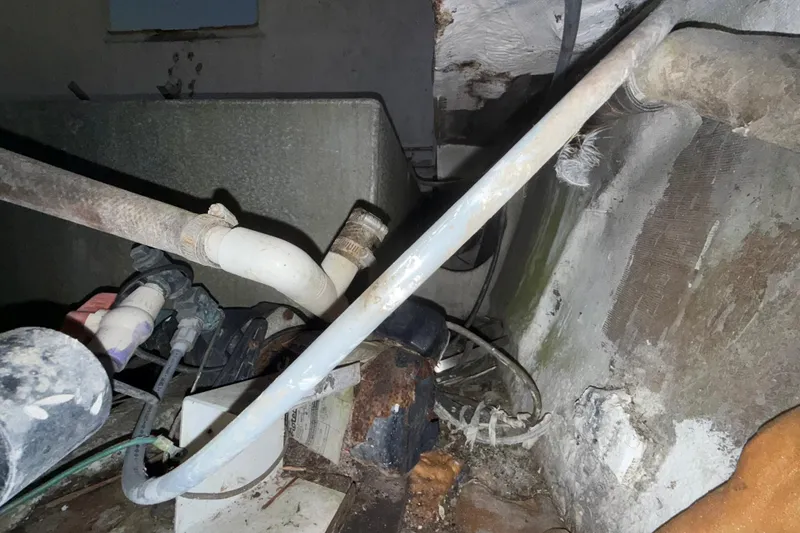 Slide: The Image of Engine room of a 1995 Bertram 46 Moppie, showing pipes and mechanical components. - 17