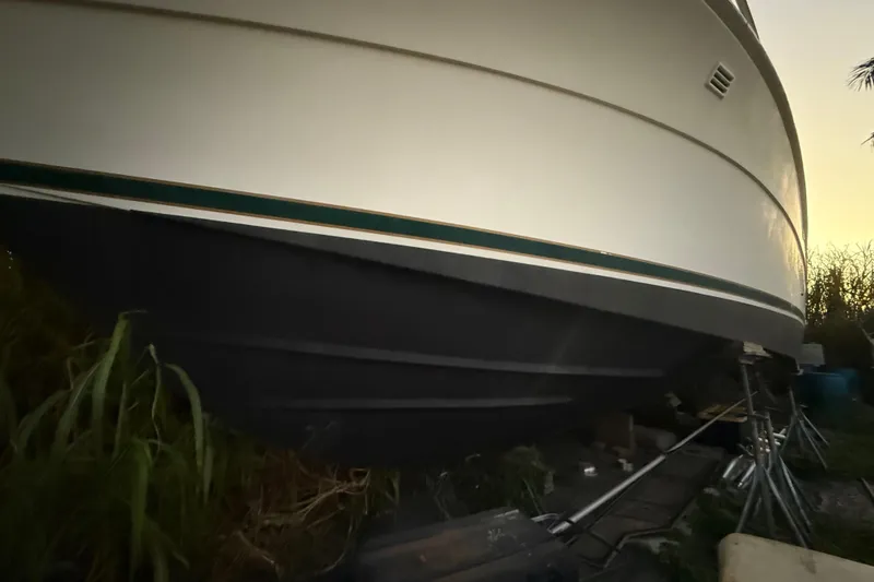 Slide: The Image of 1995 Bertram 46 Moppie boat hull on stands, side view at sunset. - 26