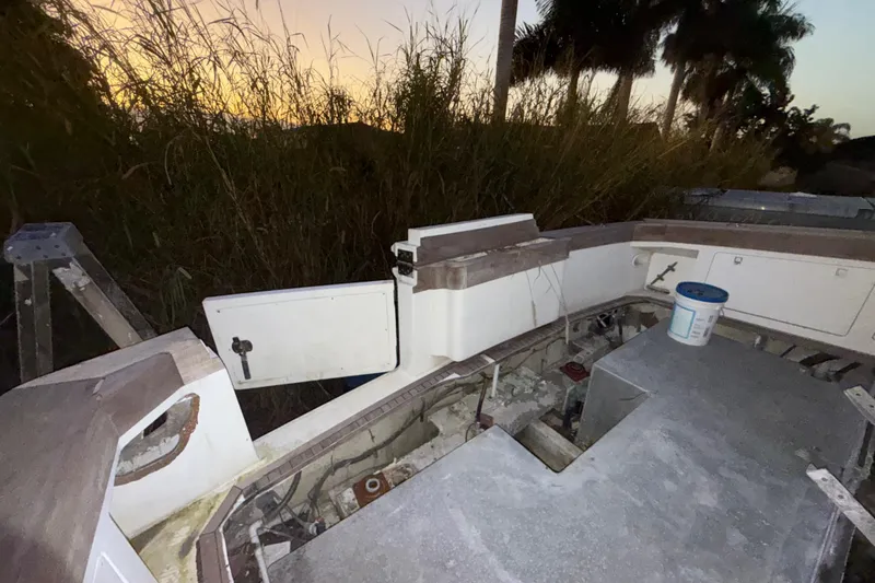 Slide: The Image of 1995 Bertram 46 Moppie boat interior, showing open compartments and maintenance area at sunset. - 38