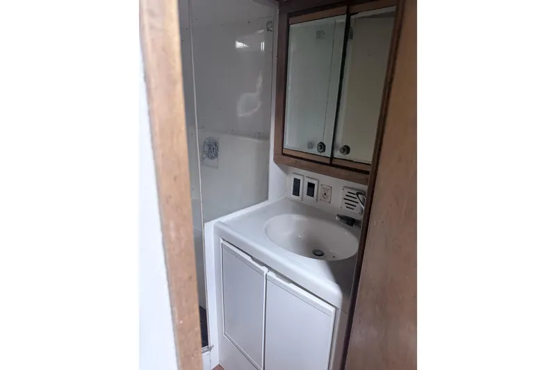 Slide: The Image of Bathroom interior of 1995 Bertram 46 Moppie yacht with sink and mirrored cabinet. - 6