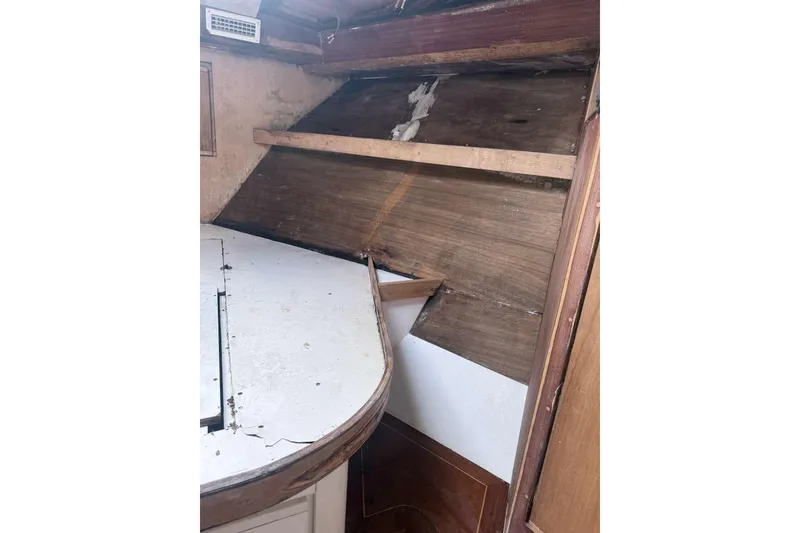 Slide: The Image of 1995 Bertram 46 Moppie interior showing worn wood paneling and table. - 9