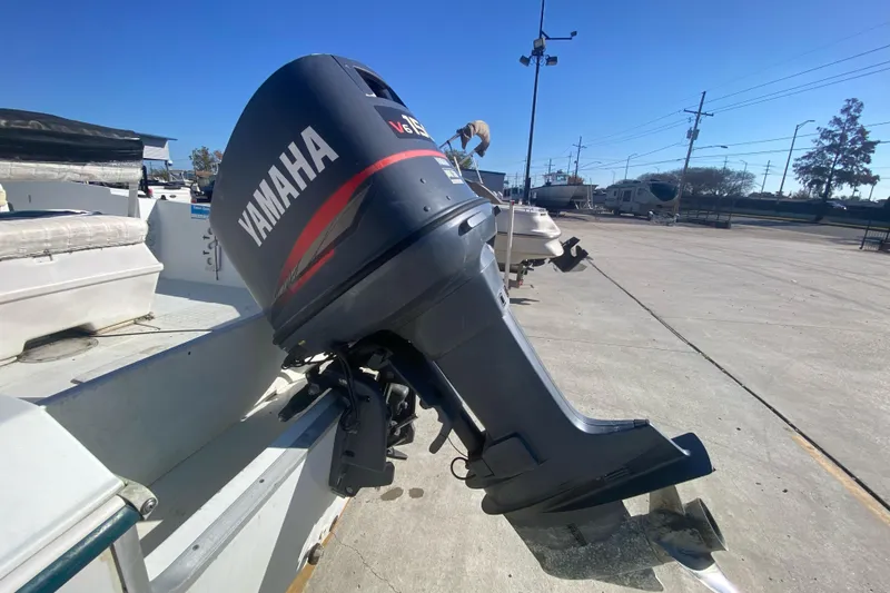 Slide: The Image of Outboard motor on 1999 Pro Sports 1850 CC boat in a parking lot. - 18