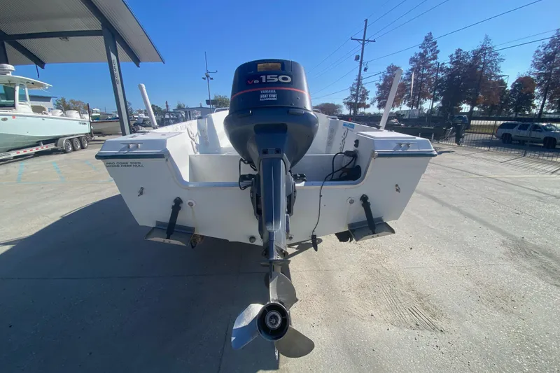 Slide: The Image of 1999 Pro Sports 1850 CC boat with Yamaha V6 150 outboard motor, parked outdoors. - 2
