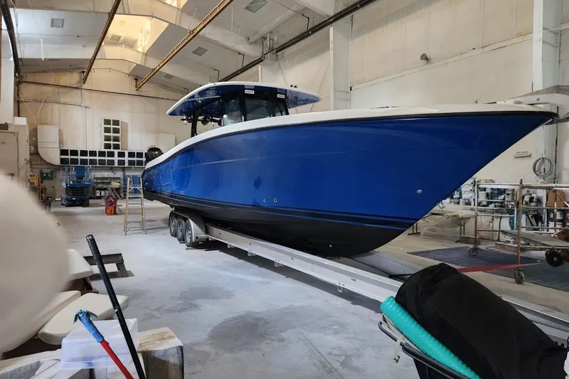 The Image of 2017 HCB 42 Siesta boat in a workshop, blue hull, on a trailer. - 0