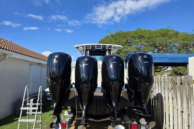 Slide: The Image of 2017 HCB 42 Siesta boat with four powerful outboard engines, parked outdoors. - 30