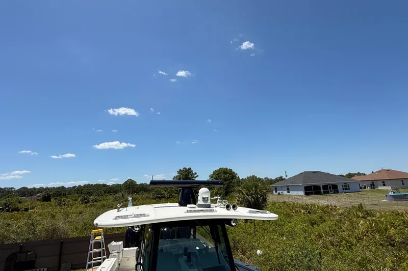 Slide: The Image of 2017 HCB 42 Siesta boat with clear blue sky and residential background. - 37
