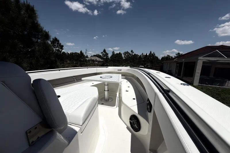 Slide: The Image of 2017 HCB 42 Siesta boat interior with seating and table under a clear sky. - 58