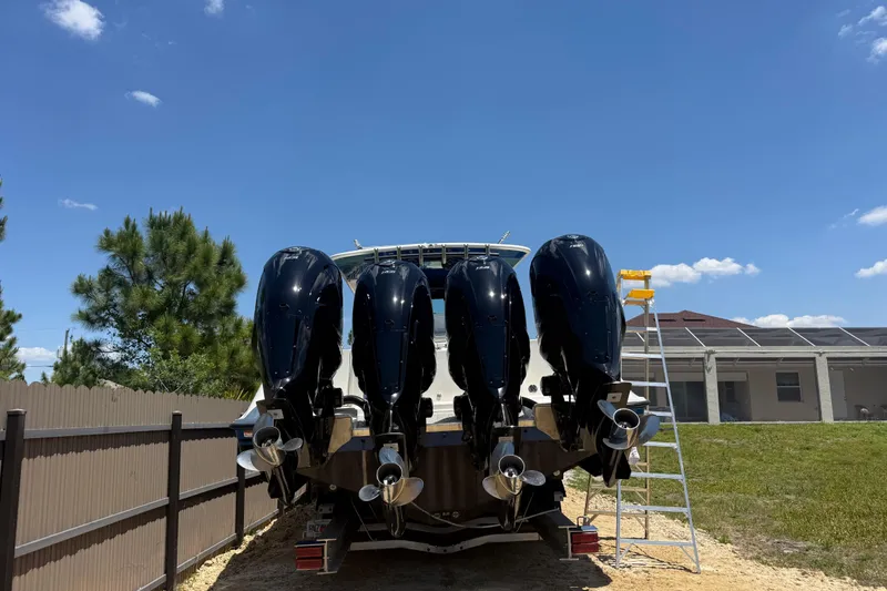 Slide: The Image of 2017 HCB 42 Siesta boat with four powerful outboard engines, parked outdoors. - 67