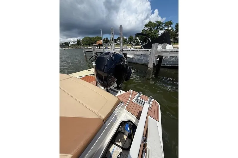 Slide: The Image of 2018 Sea Ray SPX 210 Outboard docked, showcasing rear seating and outboard motor. - 13