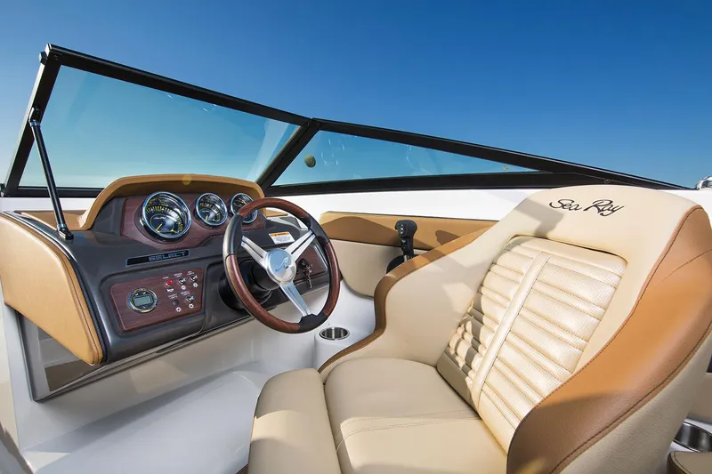 Slide: The Image of Manufacturer Provided Image: 2018 Sea Ray SPX 210 OB boat interior with tan seating on a lake. - 2