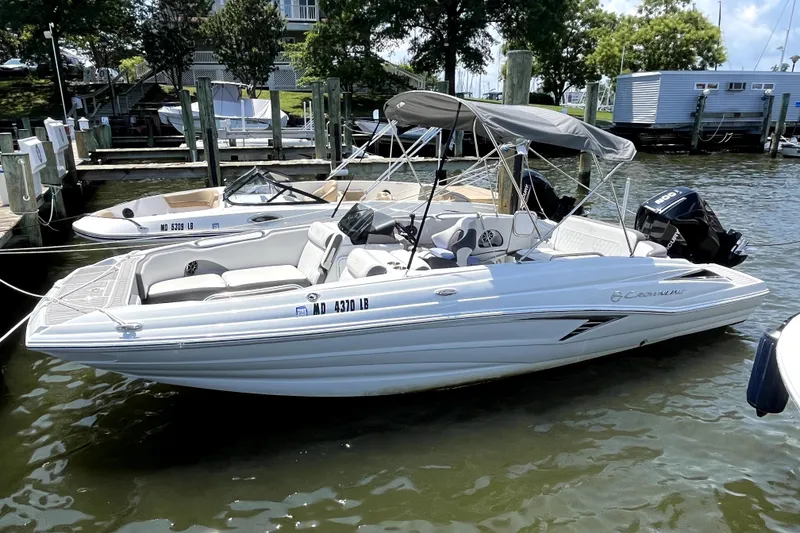 The Image of 2024 Crownline Eclipse E230 XS boat docked in a marina, featuring a sleek design. - 1