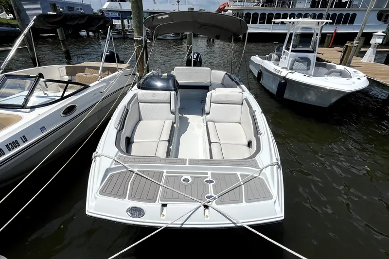 Slide: The Image of 2024 Crownline Eclipse E230 XS boat docked, featuring spacious seating and sleek design. - 3