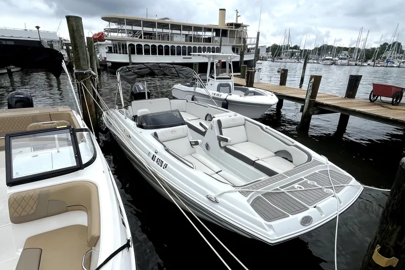 Slide: The Image of 2024 Crownline Eclipse E230 XS boat docked at marina with other vessels nearby. - 5