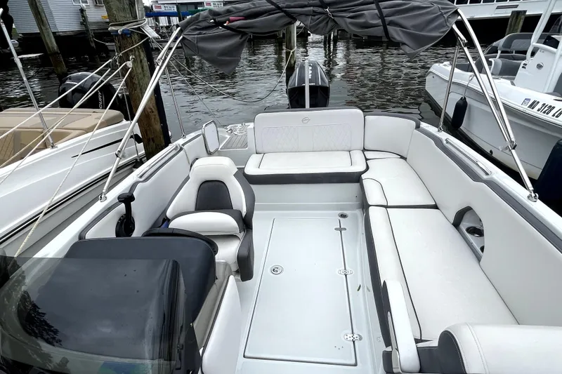 Slide: The Image of 2024 Crownline Eclipse E230 XS boat interior with white seating and canopy. - 6