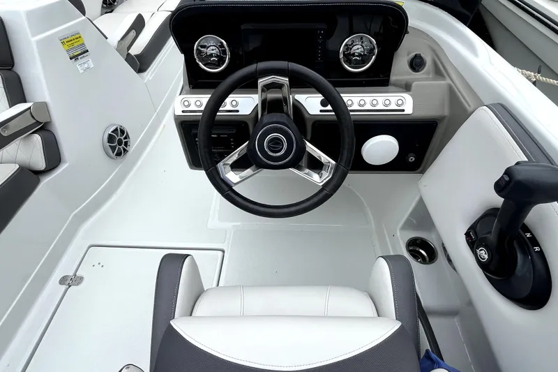 Slide: The Image of 2024 Crownline Eclipse E230 XS boat cockpit with steering wheel and controls. - 8