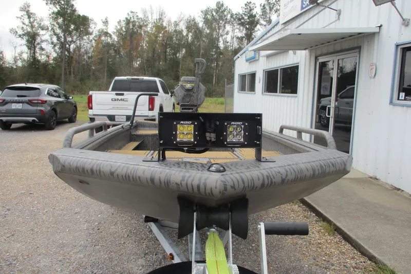 Slide: The Image of 2026 Gator Tail 1750 SAVAGE MIDDECK boat with LED lights, parked outside a building. - 3