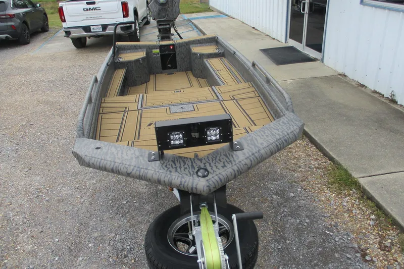 Slide: The Image of 2026 Gator Tail 1750 SAVAGE MIDDECK boat on trailer, parked near a building. - 4