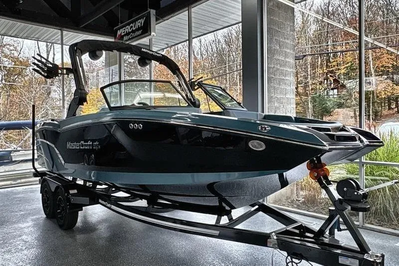 The Image of 2026 MasterCraft NXT22 boat displayed indoors on a trailer. - 0