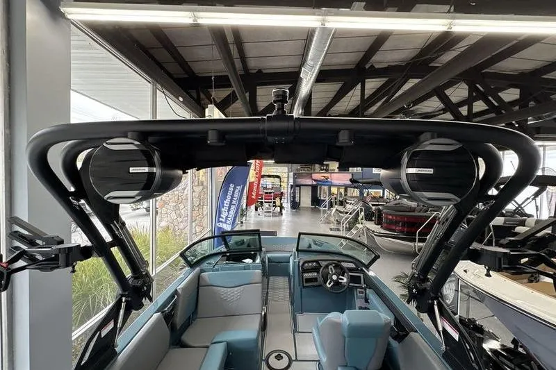 Slide: The Image of 2026 MasterCraft NXT22 boat interior with speakers and seating in a showroom. - 17