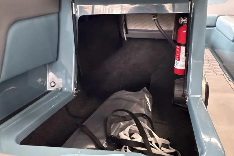 Slide: The Image of Storage compartment in 2026 MasterCraft NXT22 boat with fire extinguisher and bag. - 5