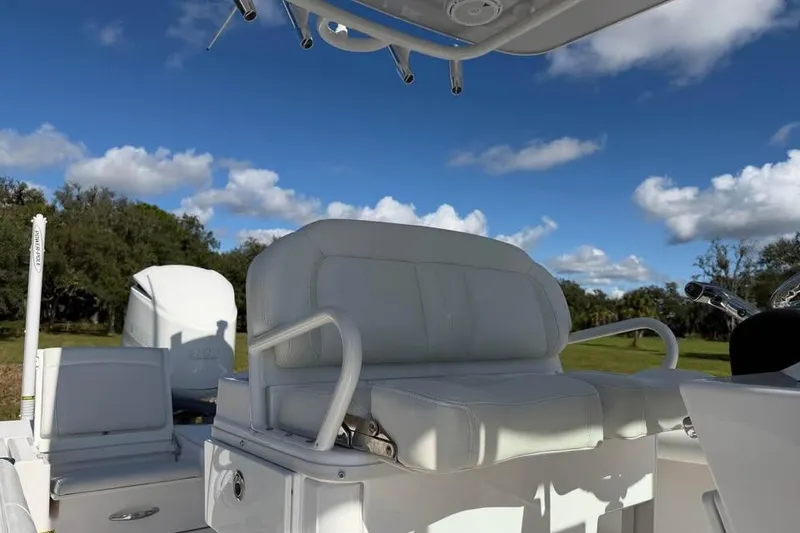Slide: The Image of 2020 Everglades 253 Center Console boat interior with white seating under blue sky. - 12